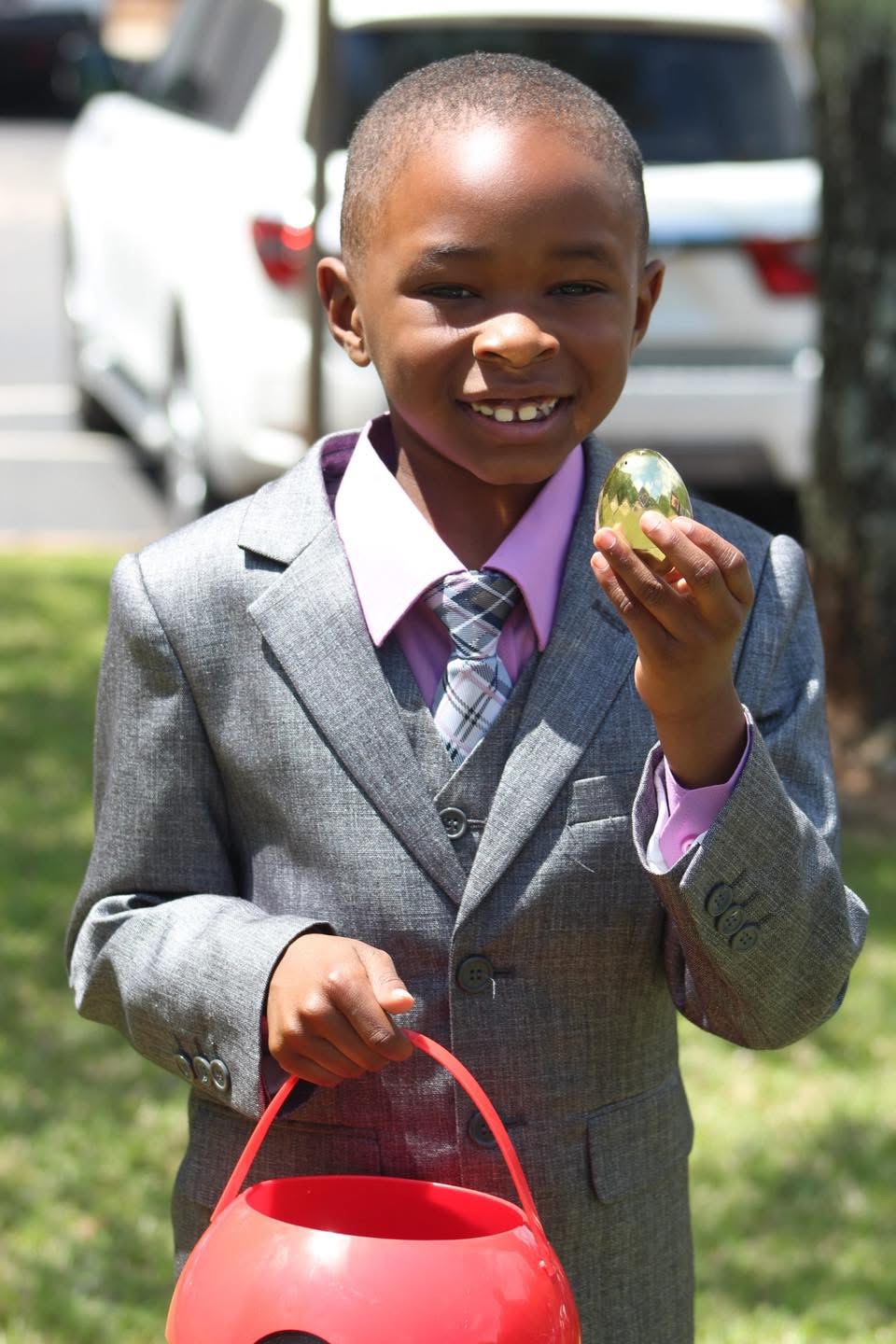 Boy holding a golden egg at the Easter egg hunt