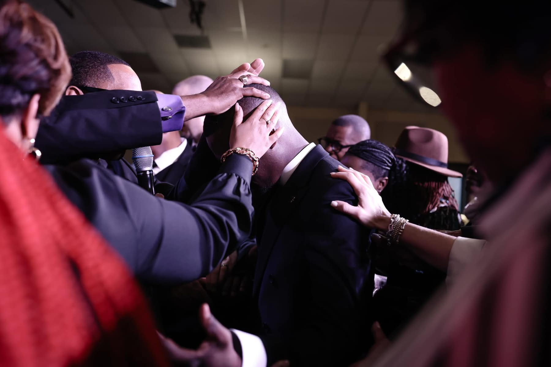 Leaders laying hands on Pastor Marty Mayes in prayer