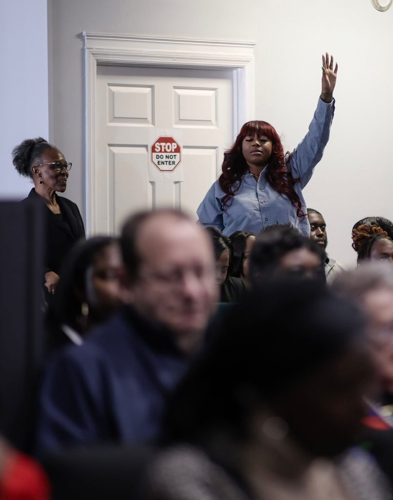 Woman worshipping with a raised hand during service